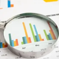 Image of spreadsheet and graphs with numbers and magnifying glass